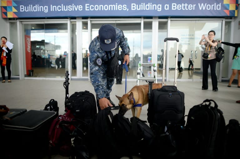 A Philippine Coastguard K9 unit inspects bags and equipments outside the Asia-Pacific Economic Cooperation (APEC) International Media Center in Manila on November 16, 2015