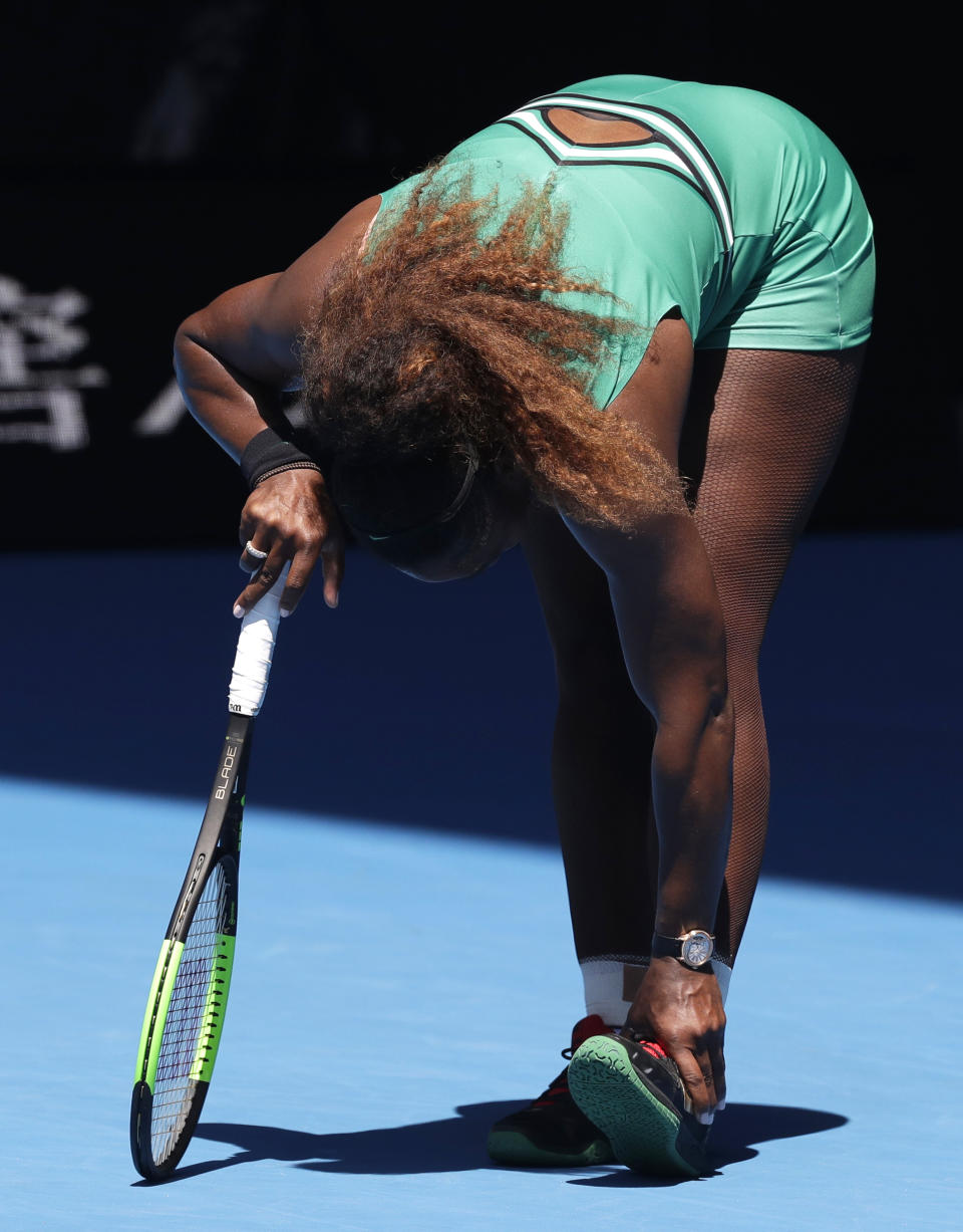 United States' Serena Williams holds her ankle during her quarterfinal match against Karolina Pliskova of the Czech Republic at the Australian Open tennis championships in Melbourne, Australia, Wednesday, Jan. 23, 2019. (AP Photo/Kin Cheung)