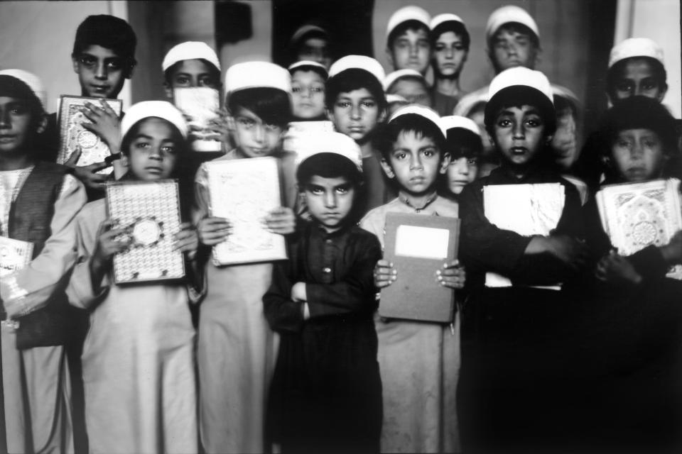 Children pose for a portrait holding the Quran inside a school in the Jama Masjid mosque, also known as Great Mosque, in Herat, Afghanistan, Thursday, June 1, 2023. (AP Photo/Rodrigo Abd)