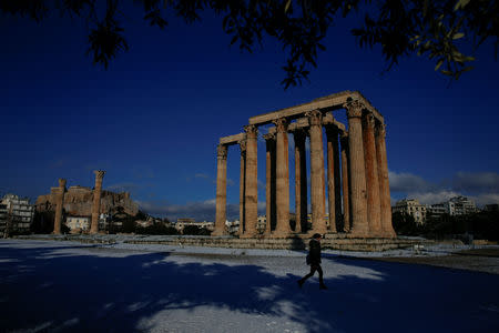 A visitor makes her way inside the archaeological site of the ancient Temple of Zeus following a snowfall in Athens, Greece, January 8, 2019. REUTERS/Alkis Konstantinidis