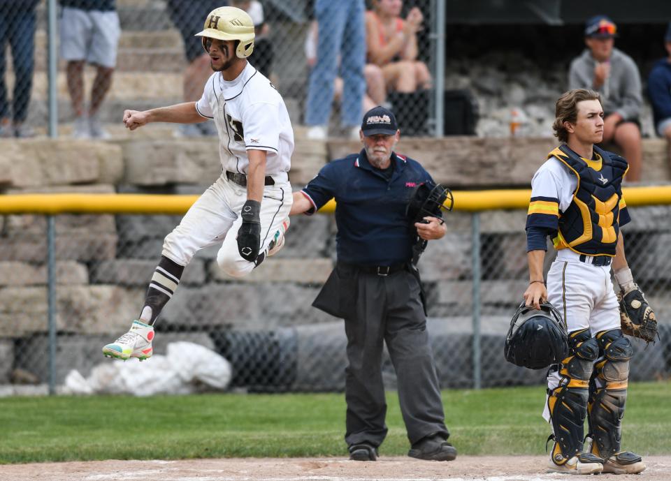 Holt senior Matthew Barger leaps as he crosses home plate against Grand Ledge Saturday, June 4, 2022, during the Div. 1 District Championship at Gorman Field in Grand Ledge. Holt won 4-3.