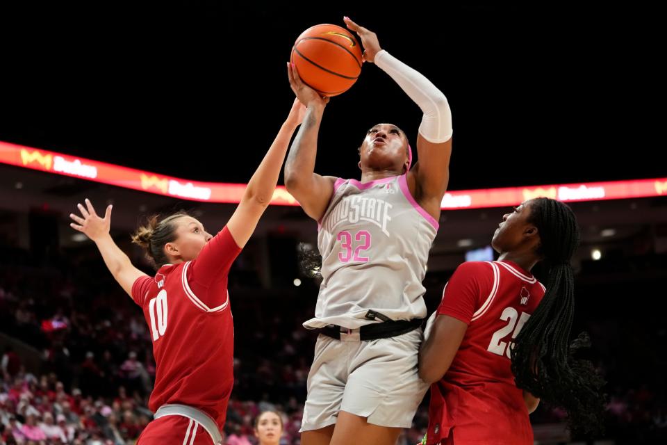 Feb 1, 2024; Columbus, OH, USA; Ohio State Buckeyes forward Cotie McMahon (32) shoots between Wisconsin Badgers forward Serah Williams (25) and guard Halle Douglass (10) during the first half of the NCAA women’s basketball game at Value City Arena.