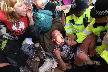 Police officers detain climate change activists at Oxford Circus during the Extinction Rebellion protest in London, Britain April 18, 2019. REUTERS/Simon Dawson