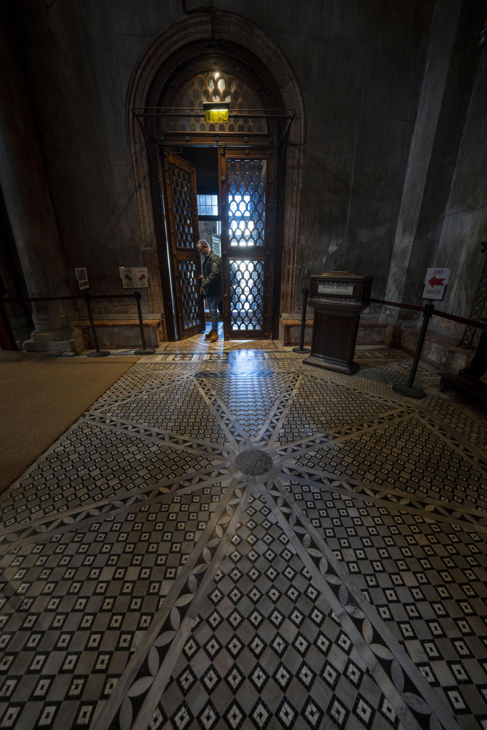 A visitor enters St. Mark's Basilica in Venice, northern Italy, Wednesday, Dec. 7, 2022, where seawaters no longer endanger the fragile marble mosaics of the floors after glass barriers that prevent seawater from flooding the 900-year-old iconic Venice's Basilica during high tides have been recently installed in St. Mark's Square that is the lowest-laying city area and frequently ends up underwater during extreme weather. (AP Photo/Domenico Stinellis)