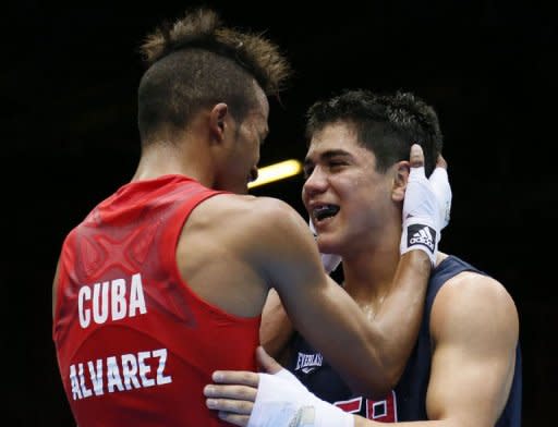 Lazaro Alvarez Estrada (L) of Cuba embraces Joseph Diaz Jr (R) of the USA following their second round Bantamweight (56kg) boxing match of the London 2012 Olympics at the ExCel Arena in London. Alvarez Estrada was awarded a 21-15 points decision