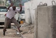 A man raises his hands as he runs from the scene of a suicide bomb attack outside Nasahablood hotel in Somalia's capital Mogadishu, June 25, 2016. REUTERS/Feisal Omar.