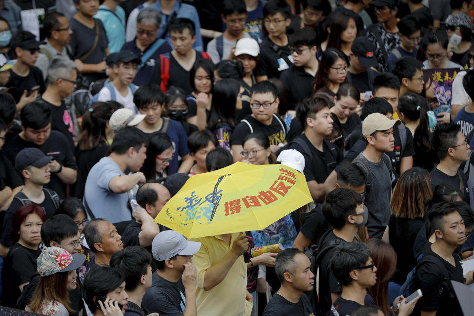 A man carries an umbrella as protesters take part in the anti-extradition bill protests march in Hong Kong, Sunday, Aug. 4, 2019. Hong Kong police said Sunday that they arrested more than 20 people for unlawful assembly, assault and other offenses after confrontations between protesters and authorities continued deep into the night. (AP Photo/Vincent Thian)