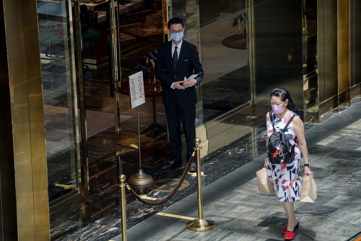 A woman wearing a face masks walks in a shopping mall in Singapore on April 3, 2020, as the government imposed tighter restrictions to combat the spread of the COVID-19 novel coronavirus. (Photo by Roslan RAHMAN / AFP) (Photo by ROSLAN RAHMAN/AFP via Getty Images)