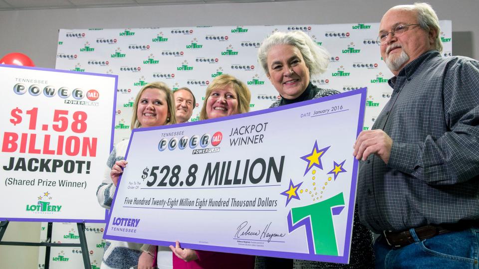 Tiffany Robinson, left; Powerball winner Lisa Robinson; Rebecca Hargrove, Tennessee Lottery president & chief executive; and Powerball winner John Robinson, hold a giant check with their portion of the $1.6 billion Powerball jackpot Jan. 15, 2016, during a press conference at the Tennessee lottery office in Nashville.