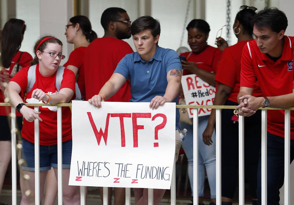 Aaron Haley, a teacher at East Forsyth Middle School holds a sign as thousands of educators and supporters from across the state come to a rally in Raleigh to march to the General Assembly in Raleigh on May 16, 2018. They are seeking higher pay, more funding for schools and more respect for the profession