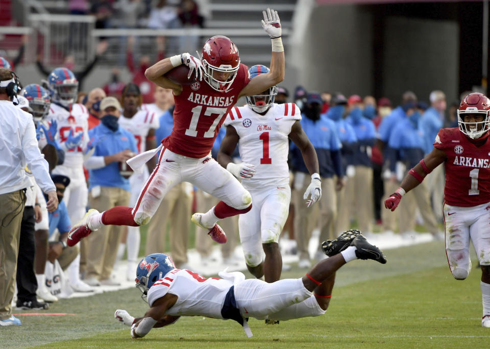 Arkansas defensive back Hudson Clark (17) leaps over Mississippi running back Tylan Knight (4) as he returns an interception during the second half of an NCAA college football game Saturday, Oct. 17, 2020, in Fayetteville, Ark. (AP Photo/Michael Woods)