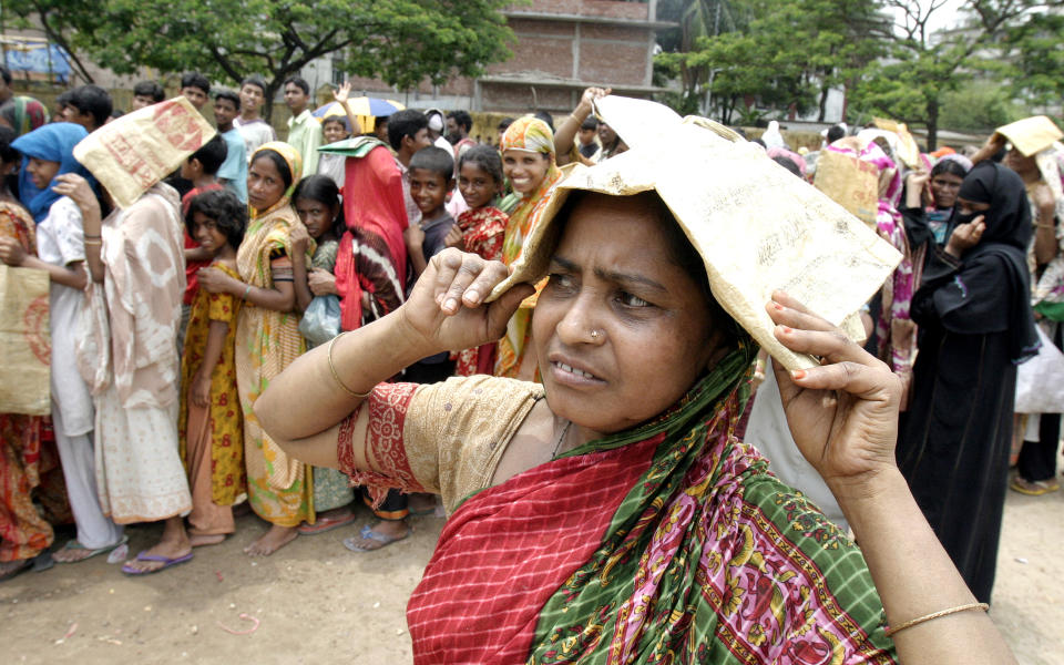 Eine Frau in Bangladesch schützt sich mit einer Papiertüte auf dem Kopf vor extremer Hitze