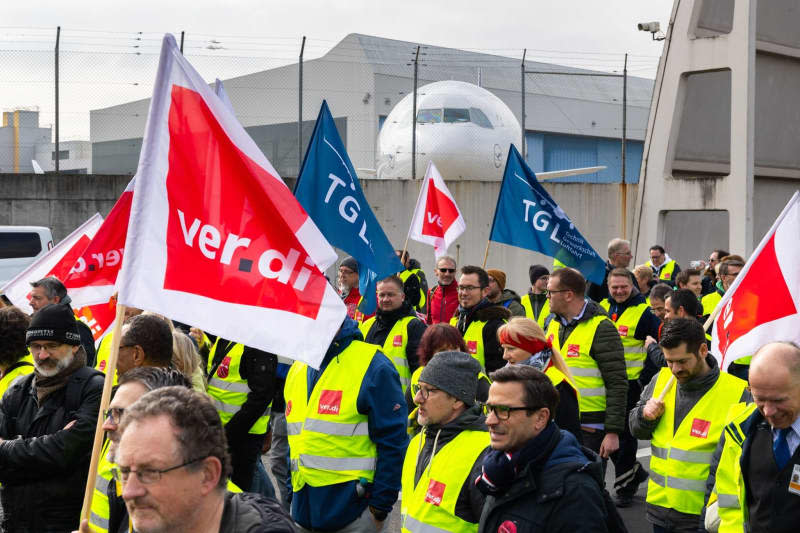 A protest march of strikers marches from the Lufthansa Aviation Center to Terminal 1 with banners and Verdi flags. German airline Lufthansa estimates industrial action by employees has cost the firm €250 million ($272 million) so far this year. Lando Hass/dpa