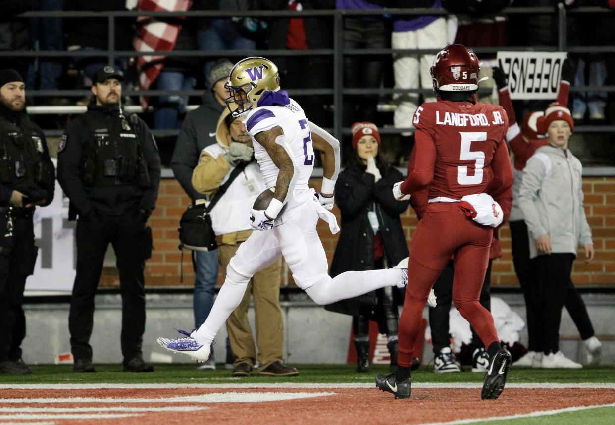 Washington wide receiver Ja'Lynn Polk (2) runs for a touchdown near Washington State defensive back Derrick Langford Jr. (5) during the first half of the Apple Cup on Nov. 26, 2022, in Pullman.