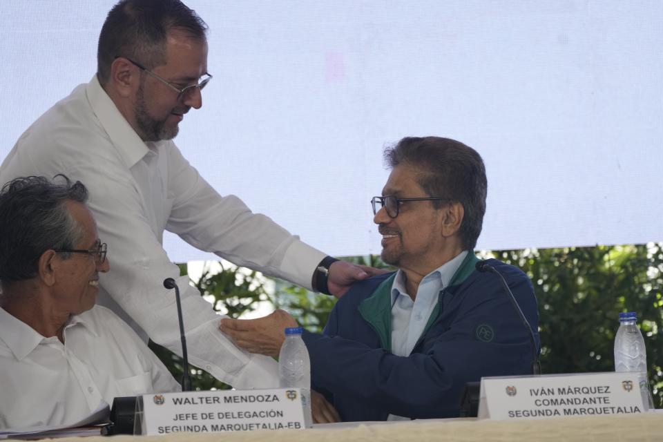 El ministro de Relaciones Exteriores de Venezuela, Yvan Gil, arriba, le da la mano a Iván Márquez, comandante en jefe del grupo armado colombiano Segunda Marquetalia, durante el inicio de las conversaciones de paz con el gobierno colombiano en Caracas, Venezuela, el lunes 24 de junio de 2024. A la izquierda Walter Mendoza, jefe de negociaciones del grupo armado. (AP Foto/Ariana Cubillos)