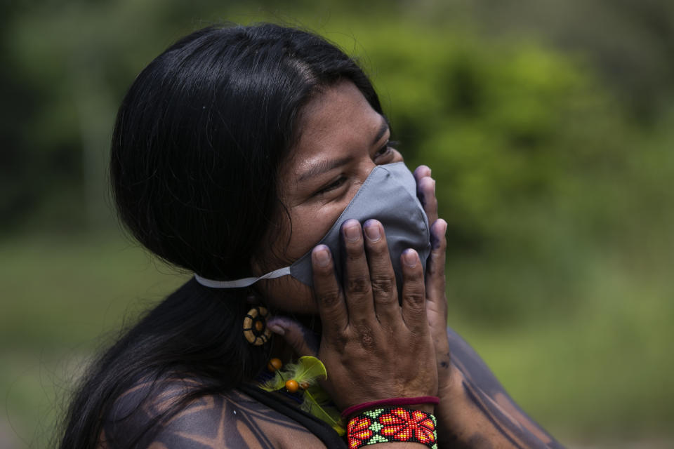 Suzana, a 22-year-old Guarani woman, smiles during an interview in the Mata Verde Bonita village in Marica, Rio de Janeiro state, Brazil, Thursday, Feb. 25, 2021, where healthcare workers are making the rounds with coolers containing doses of China's Sinovac COVID-19 vaccine as part of a mass immunization program aimed at inoculating all of Rio’s 16 million residents by the end of the year. (AP Photo/Bruna Prado)