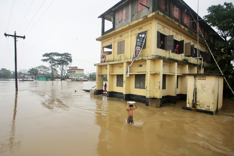 Boy wades through a flooded area during a widespread flood in Sylhet