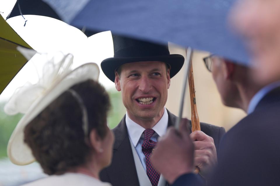 Prince William helped shelter guests from the rain at yesterday’s garden party (AP)