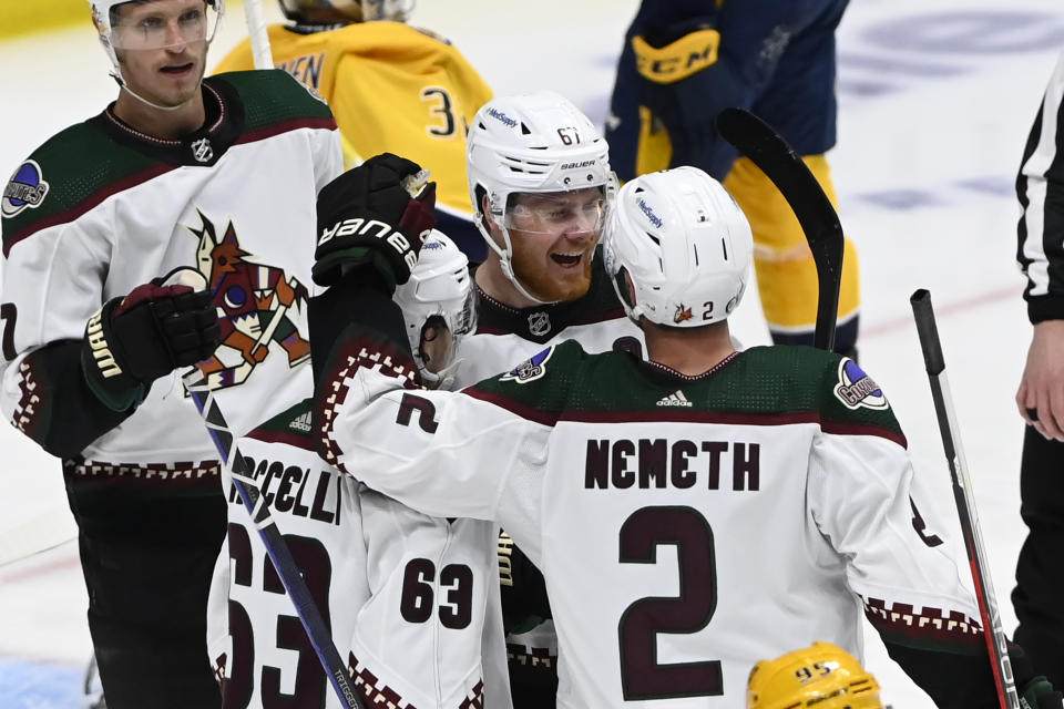 Arizona Coyotes left wing Lawson Crouse (67) celebrates after his goal with Matias Maccelli (63) and Patrik Nemeth (2) during the third period of an NHL hockey game against the Nashville Predators, Monday, Feb. 13, 2023, in Nashville, Tenn. (AP Photo/Mark Zaleski)