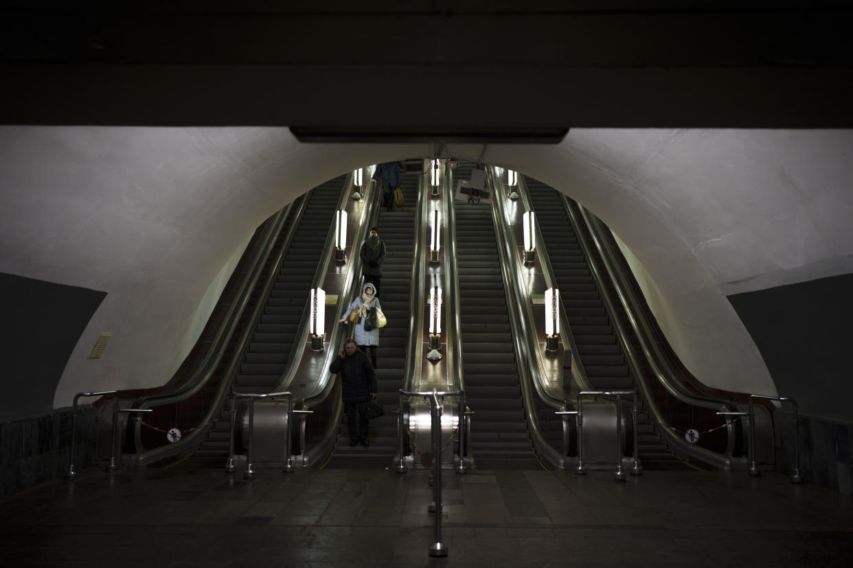 People ride the escalator as they arrive to the reopened Maidan Nezalezhnosti (Independence Square) metro station in Kyiv, Ukraine, Tuesday, Dec. 20, 2022. Two main metro stations in Kyiv reopened today for the first time since war began nearly 10 months ago. (AP Photo/Felipe Dana)