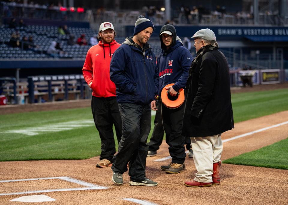 WooSox field superintendent Elliot Linstrum, second from left, talks with WooSox president Dr. Charles Steinberg, right, ahead of the Worcester Red Sox' game with the Buffalo Bisons on Friday at Polar Park