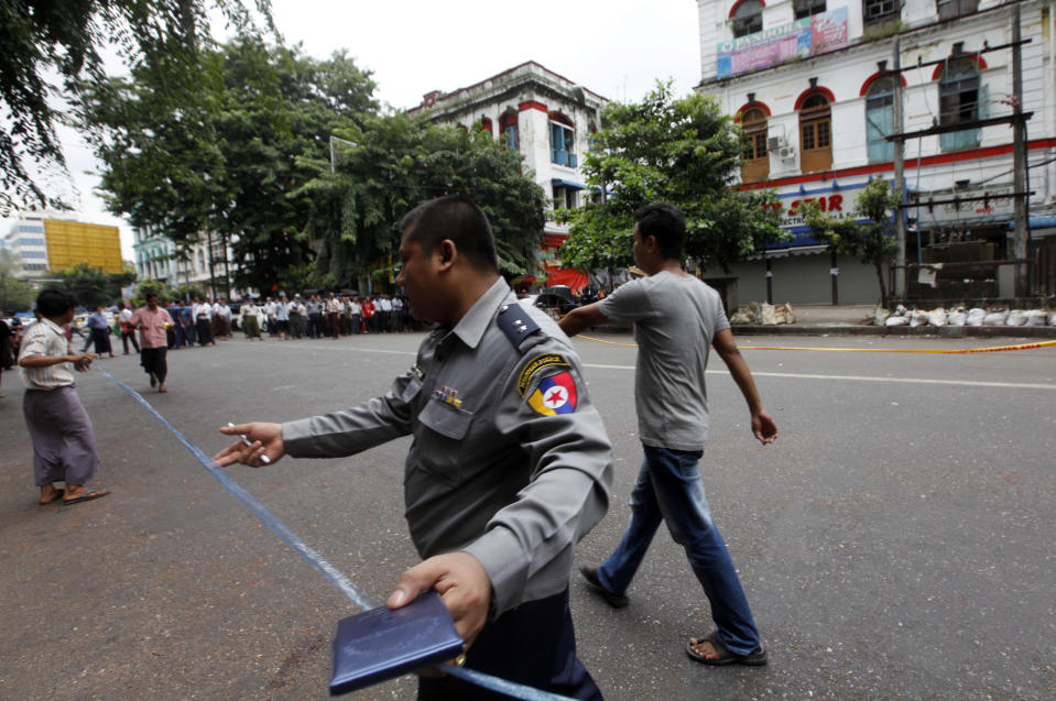 A Myanmar policeman seals off an area after a bomb squad found a suspicious looking packet in downtown Yangon, Myanmar, Tuesday, Oct. 15, 2013. Police urged vigilance after several small bombs exploded in and around Myanmar's largest city of Yangon in recent days. No one claimed responsibility for the boasts and it was not immediately clear if they were related. (AP Photo/Khin Maung Win)