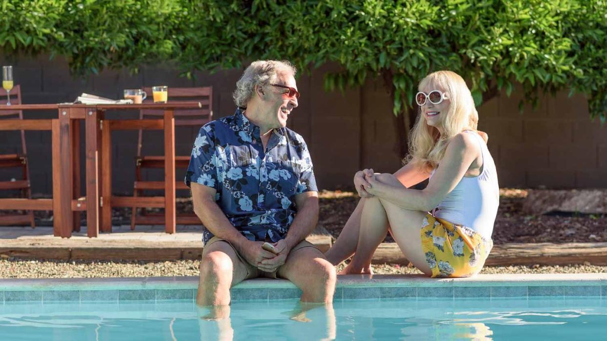 Couple laughing near swimming pool