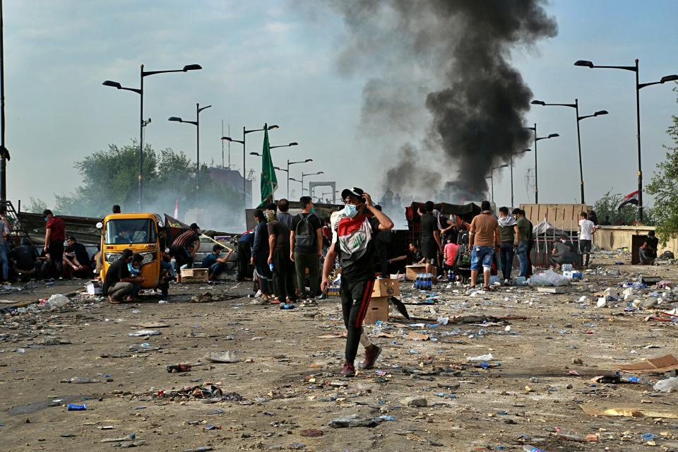 Anti-government protesters set a fire while Iraqi Security forces close the bridge leading to the Green Zone during a demonstration in Tahrir square in Baghdad, Iraq, Sunday, Oct. 27, 2019. Protests have resumed in Iraq after a wave of anti-government protests earlier this month were violently put down. At least 149 people were killed in a week of demonstrations earlier in October. (AP Photo/Hadi Mizban)