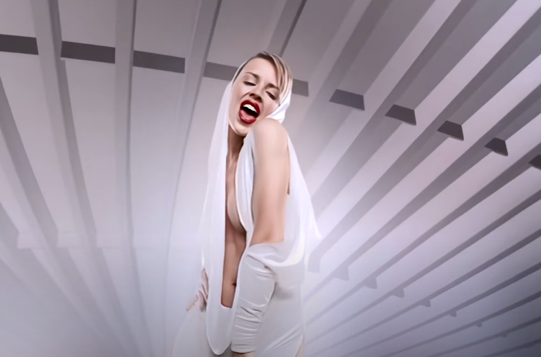 Screenshot of Kylie from the music video with her in a white jumpsuit. 