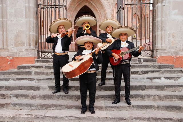 <p>Jeremy Woodhouse/Getty Images</p> A mariachi band performs on the steps of Parroquia de San Miguel Arcángel cathedral.