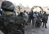 Military fans, dressed as soldiers and the charity's red heart symbol, pose for a photo as they collect money for Poland's most popular nationwide fundraiser for health purposes, the Great Orchestra of Christmas Charity, that was postponed by two weeks due to the pandemic, in downtown Warsaw, Poland, on Sunday, Jan. 31, 2021. Anti-government protesters angry about a near-total abortion ban suspended their marches for the weekend to show solidarity and ensure that they didn't steal the spotlight from the event. (AP Photo/Czarek Sokolowski)