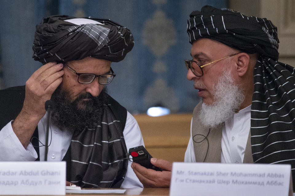 FILE - In this May 28, 2019 file photo, Mullah Abdul Ghani Baradar, the Taliban group's top political leader, left, and Sher Mohammad Abbas Stanikzai, the Taliban's chief negotiator, talk to each other during a meeting in Moscow, Russia. Afghanistan’s Taliban leaders agreed they wanted a deal with the United States, but some among them were in more of a hurry than others. Even before U.S. President Donald Trump cancelled a mysterious Camp David summit on Saturday, Sept. 7, 2019, the Taliban negotiators were at odds with the council of leaders, or shura, that rules the Islamic movement. (AP Photo/Alexander Zemlianichenko, File)