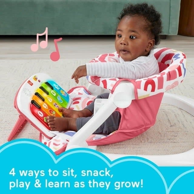 Infant in a multi-use seat with piano toy, learning and play concept