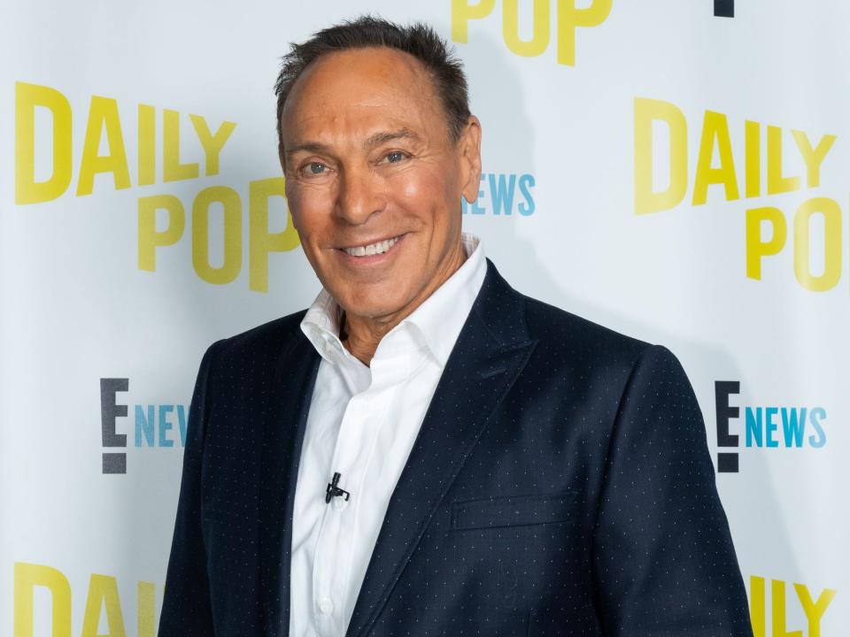 Neil Lane smiles in front of a white and yellow backdrop.