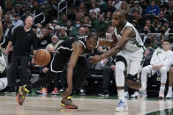 Milwaukee Bucks' Khris Middleton, right, passes the ball past Brooklyn Nets' Kevin Durant (7) during the first half of an NBA basketball game Tuesday, Oct. 19, 2021, in Milwaukee. (AP Photo/Morry Gash)