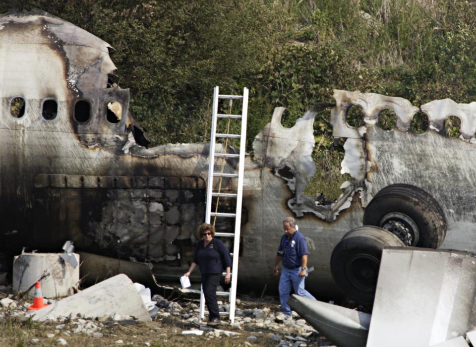 FILE - In this Wednesday Aug. 3, 2005, file photo, crash investigators examine the wreckage of Air France flight 358 at Pearson Airport in Toronto. All 309 people on the Airbus A340 survived. (AP Photo/The Canadian Press, Frank Gunn)