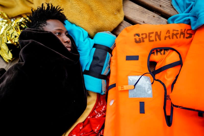 A migrant rests on board a NGO Proactiva Open Arms rescue boat in the central Mediterranean Sea