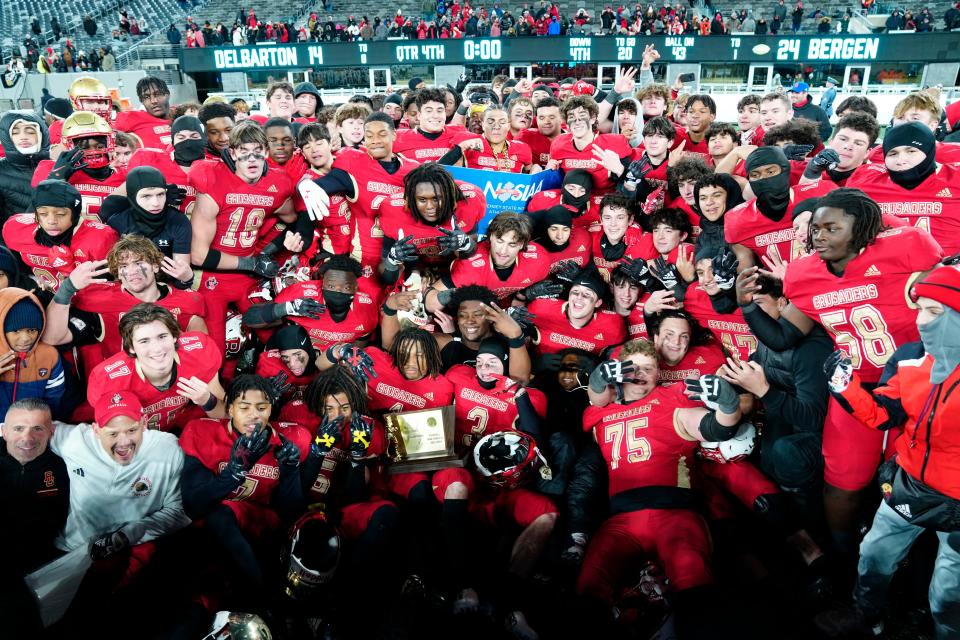 The Bergen Catholic Crusaders pose for a photograph as they celebrate their 24-14 victory over Delbarton to become the NJSIAA Non-Public A State Champions for the third consecutive year, Tuesday, November 28, 2023.