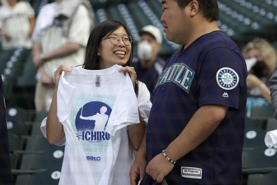 A fan holds up a commemorative shirt for former Seattle Mariners player Ichiro Suzuki on the day he is inducted into the Mariners Hall of Fame in a pregame ceremony before a baseball game between the Mariners and the Cleveland Guardians, Saturday, Aug. 27, 2022, in Seattle. Ichiro, who prefers to use only his first name, joins nine other Mariners already in the Mariners HOF. He is a 10-time All-Star and American League Rookie of the Year in 2001.. (AP Photo/John Froschauer)