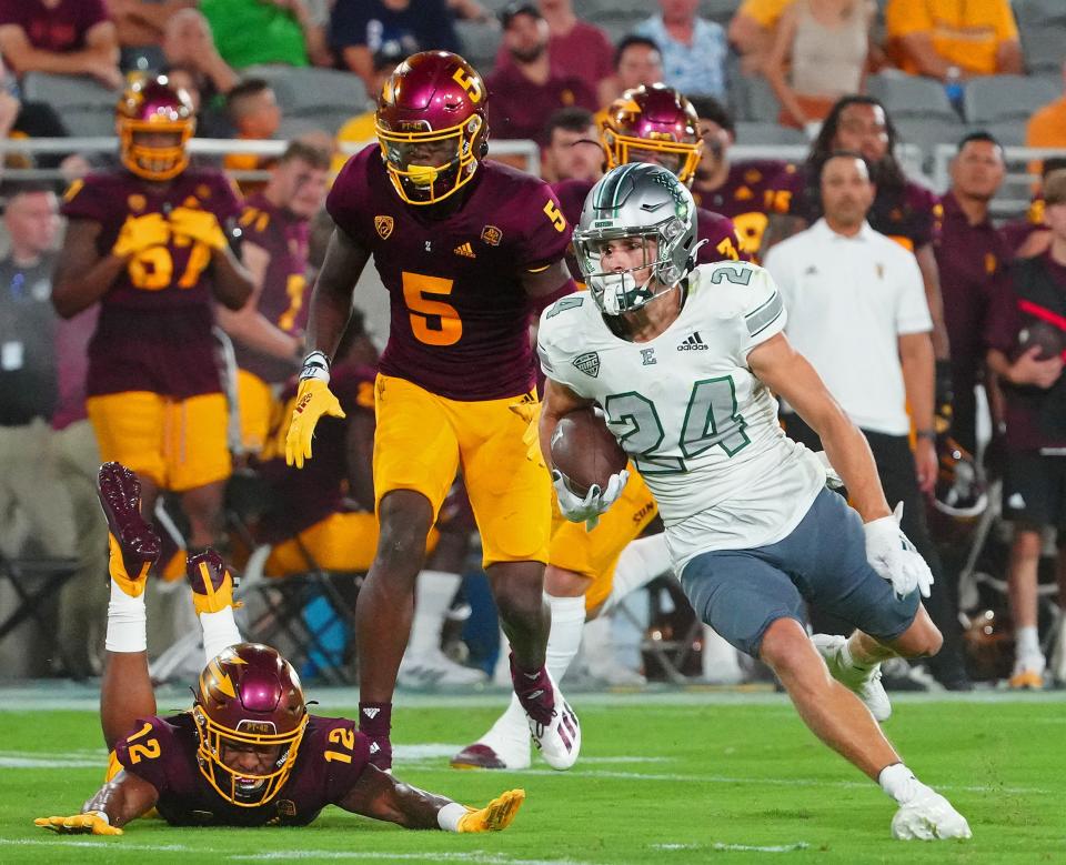 September 17, 2022; Tempe, Arizona; USA; Eastern Michigan wide receiver Tanner Knue (24) breaks a tackle from ASU defensive back Kejuan Markham (12) during a game at Sun Devil Stadium.