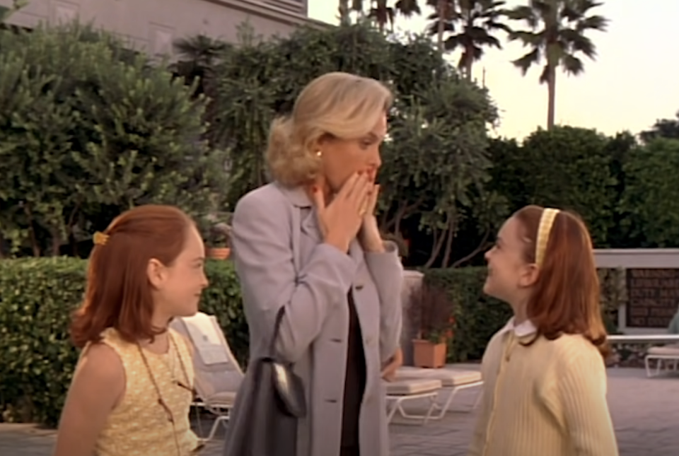 Annie and Hallie watch their mother, dressed in a suit, react with surprise, in 'The Parent Trap'