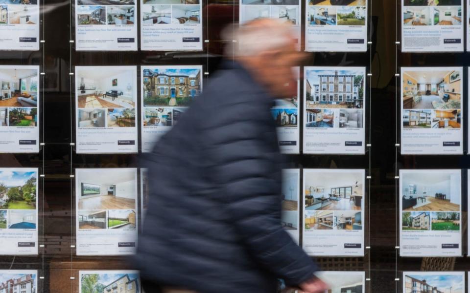 A pedestrian passes an estate agents window advertising properties - Chris Ratcliffe/Bloomberg
