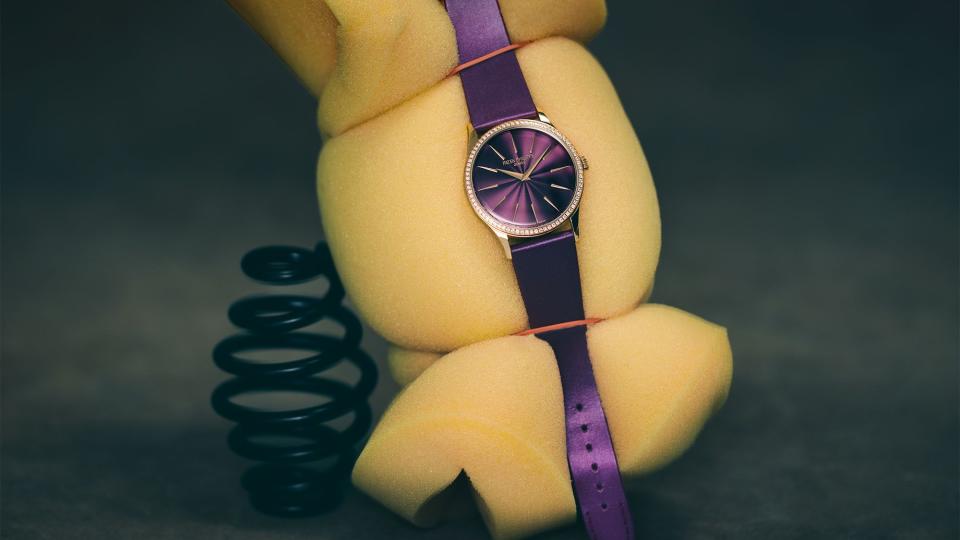 purple face watch with shiny purple band on a piece of yellow foam