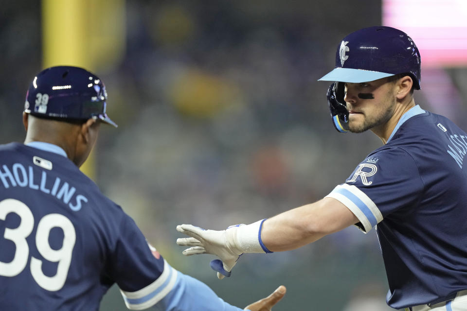 Kansas City Royals' Michael Massey, left, celebrates with first base coach Damon Hollins (39) after hitting a two-run single during the sixth inning of a baseball game against the Baltimore Orioles Friday, April 19, 2024, in Kansas City, Mo. (AP Photo/Charlie Riedel)