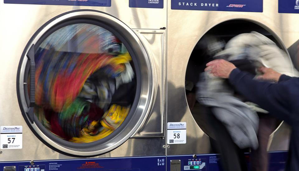 Akron residents toss their clothes into dryers during a free laundry event hosted by the city at Super Clean Laundromat on Brittain Road Thursday.