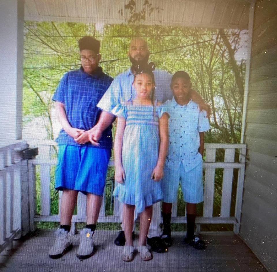 In this undated photo, Kevin Boston stands with his three children. Boston, a 45-year-old single father, was shot and killed by Charlotte-Mecklenburg Police officers Sunday, June 26, 2022. Police say Boston, a suspect in an armed robbery, fired a gun at officers. Courtesy of Mario Black