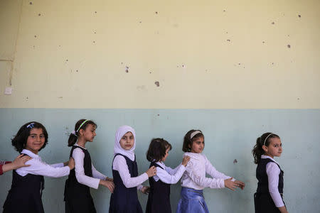 Pupils walk out from their classroom at an elementary school in eastern Mosul, Iraq, April 17, 2017. REUTERS/Marko Djurica