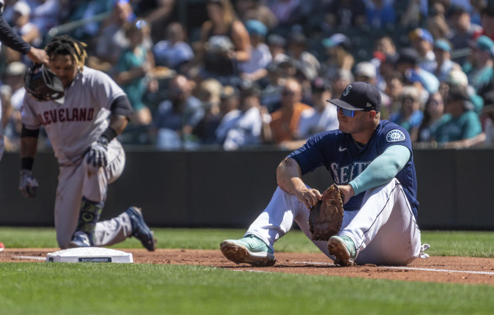 Seattle Mariners first baseman Ty France, right, sits on the field after a collision with Cleveland Guardians' Jose Ramirez during the first inning a baseball game, Thursday, Aug. 25, 2022, in Seattle. (AP Photo/Stephen Brashear)