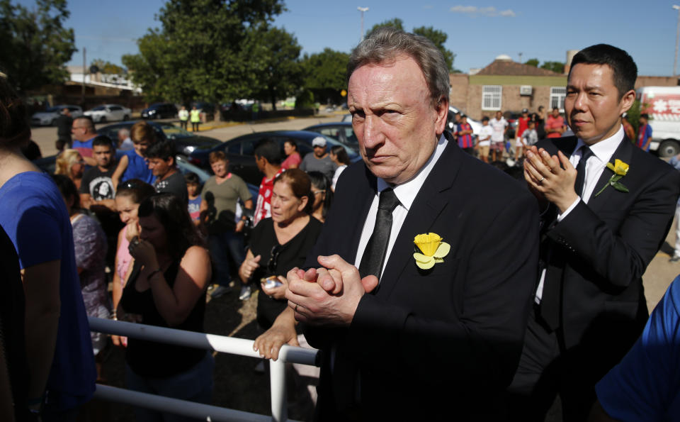 Cardiff City manager Neil Warnock, second righ, and Cardiff City CEO Ken Choo, right, applaud during the burial of Emiliana Sala, at the cemetery in Santa Fe, Argentina, Saturday, Feb. 16, 2019. The Argentina-born forward died in an airplane crash in the English Channel last month when flying from Nantes in France to start his new career with English Premier League club Cardiff. (AP Photo/Natacha Pisarenko)