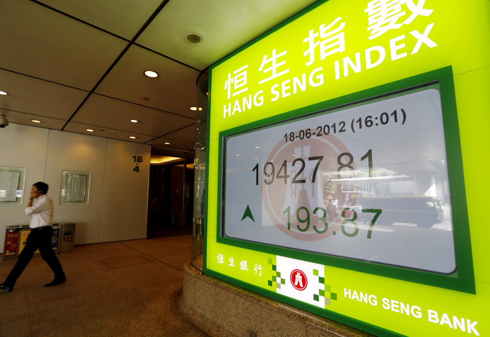 A man walks near a screen displaying stock index outside a local bank in Hong Kong Monday, June 18, 2012. Asian stock markets were up sharply Monday after elections in Greece eased fears of global financial turmoil, but analysts warned that the economic crisis shaking the 17 nations that use the euro was far from over. (AP Photo/Vincent Yu)